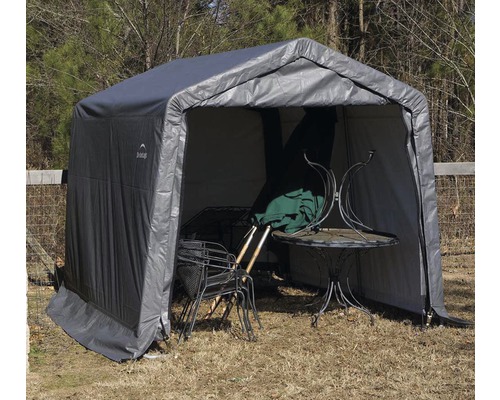 Abri d''outils gris avec table de jardin et chaises à l''intérieur