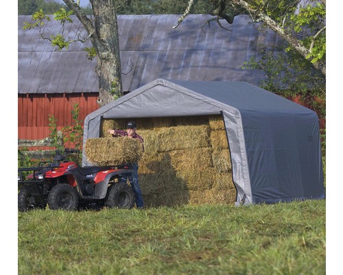 Tente de stockage grise avec des balles de foin et une personne