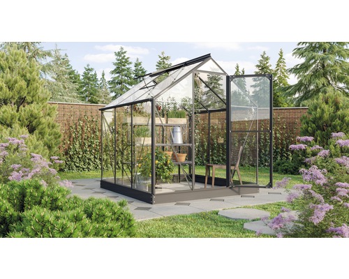 Gewächshaus mit Regalen und Pflanzen im Garten.