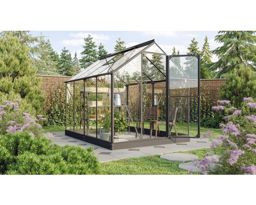 Serre avec porte ouverte et plantes dans le jardin