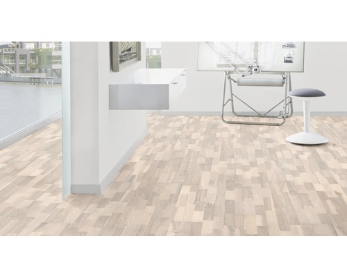 Helles Zimmer mit Holzboden im Fischgrätmuster, Schreibtisch und Hocker