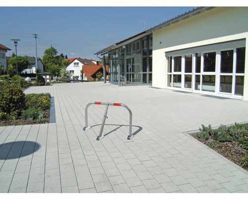 Parkplatzsperre auf gepflasterter Fläche vor Gebäude