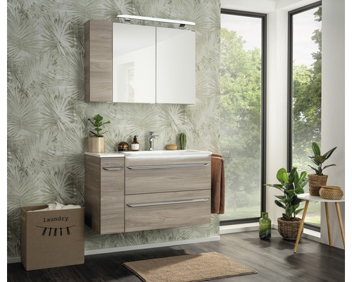 Badezimmer mit Waschtisch, Spiegelschrank und Wäschekorb in einem hellen, modernen Design