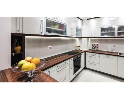 Helle Küche mit weißen Schränken, dunklen Arbeitsplatten und modernen Geräten.