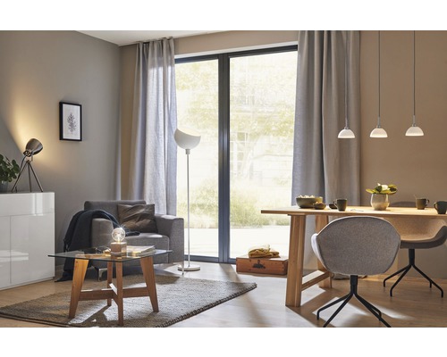 Wohnzimmer mit Sessel, Tisch, Stehlampe und Pendelleuchten