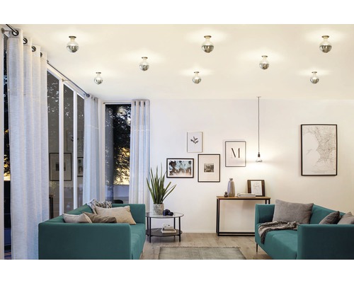 Helles Wohnzimmer mit Deckenleuchten, Sofas und Dekorationsartikeln