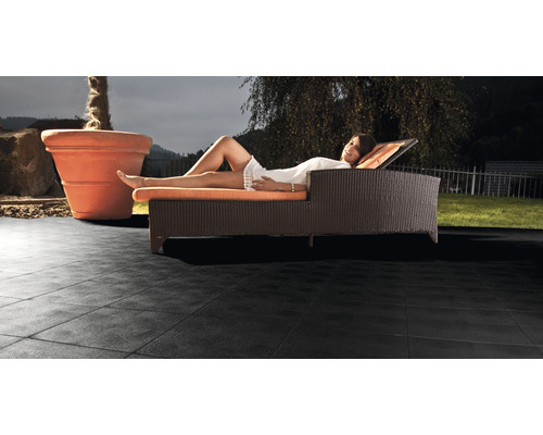 Frau entspannt sich auf einer Sonnenliege auf Terrassenplatten