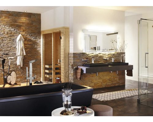 Salle de bains lumineuse avec baignoire, double vasque, sauna et vélo d''appartement