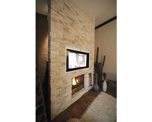 Salon avec cheminée et télévision dans un mur de pierre