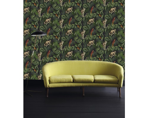 Zimmer mit Dschungeltapete, darauf Affen und Papageien, sowie einem Sofa und einer Stehlampe