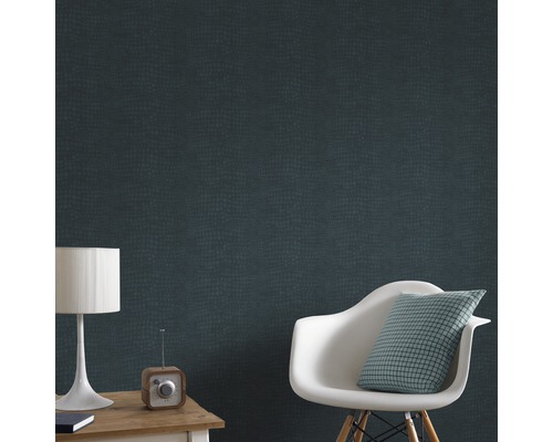 Pièce avec papier peint en cuir de reptile, chaise, coussin, lampe de table et radio