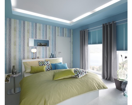 Chambre lumineuse avec lit double, papier peint à motifs et fenêtre avec rideaux et stores