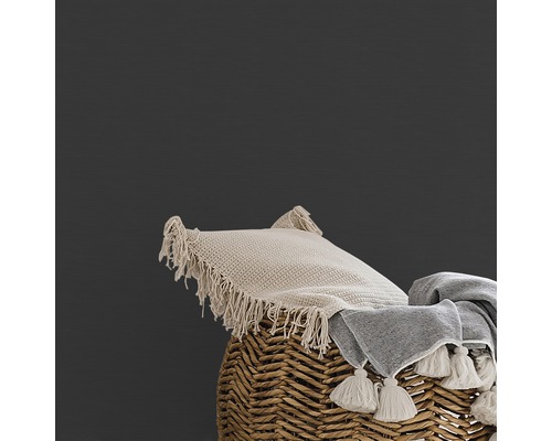 Dekokissen und Decke auf geflochtenem Korb