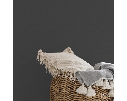 Kissen und Decke mit Quasten auf einem geflochtenen Korb