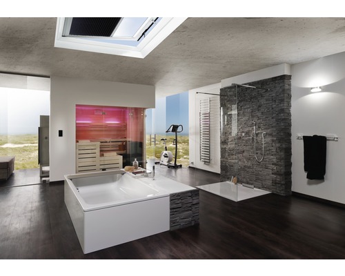 Salle de bains lumineuse avec baignoire, douche, sauna et appareil de musculation devant une grande fenêtre