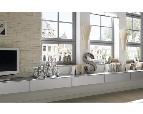 Helles Wohnzimmer mit weißen Möbeln, Dekoration und großen Fenstern.