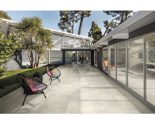 Terrasse avec mobilier de jardin devant une maison moderne avec portes coulissantes