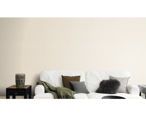 Wohnzimmer mit weissem Sofa, Kissen und beiger Tapete