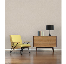 Salon avec fauteuil jaune, commode en bois, lampe et livres