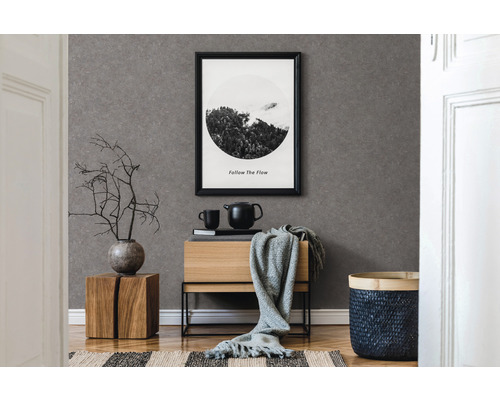Chambre décorative avec papier peint gris, meubles en bois et image encadrée au mur.