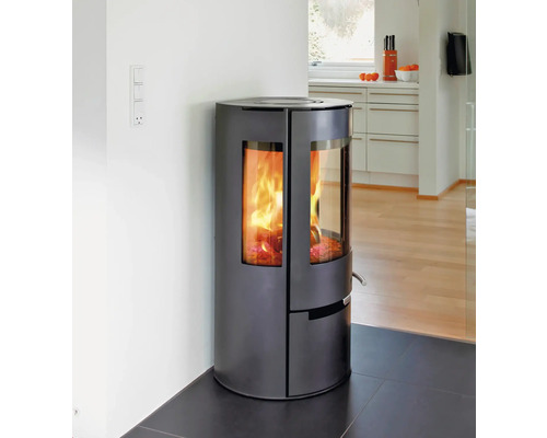 Poêle à bois avec vitre et bois qui brûle dans une pièce à vivre.