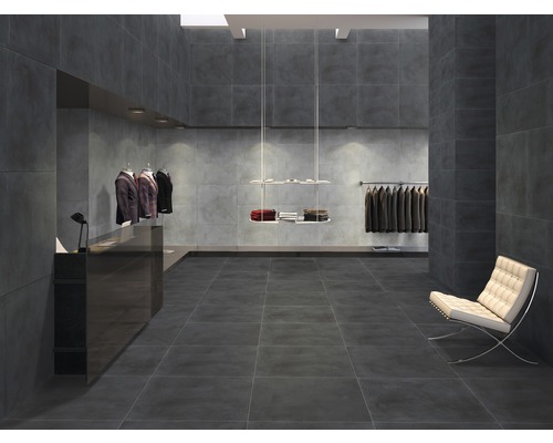 Intérieur moderne avec carrelage foncé au sol et aux murs, portant à vêtements et siège.