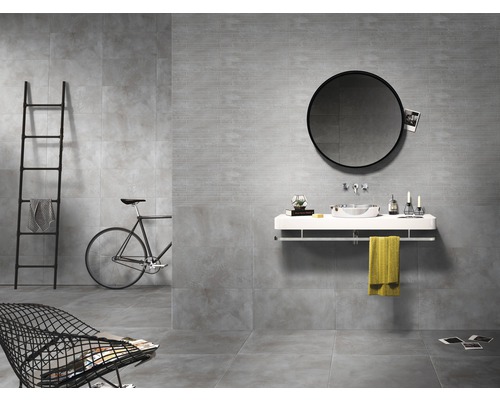 Salle de bain moderne avec carrelage gris, miroir rond et accessoires élégants