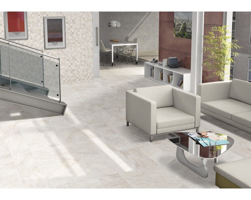 Pièce lumineuse avec carrelage au sol, escalier, coin salon et décorations pour une ambiance de vie moderne.