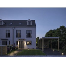 Ansicht eines Wohnhauses mit Carport und Gartenbeleuchtung bei Dämmerung.