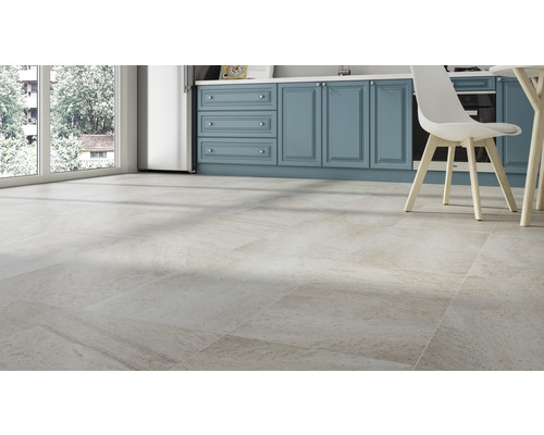 Cuisine claire et spacieuse avec carrelage au sol aspect pierre naturelle et meubles de cuisine