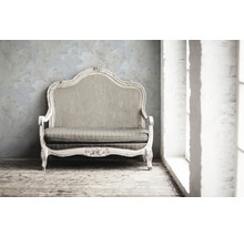Dekoratives Sofa im Vintage Stil mit Polsterung vor einer Wand