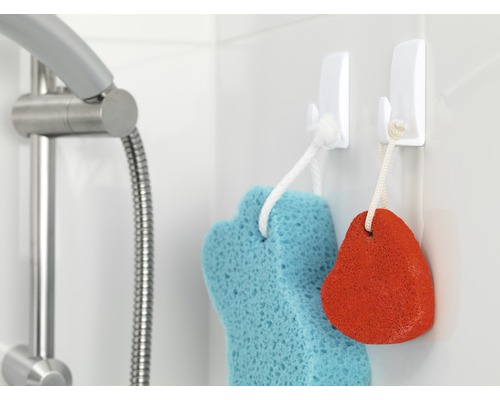 Scène de salle de bains avec douche, éponge de bain et pierre ponce sur des crochets