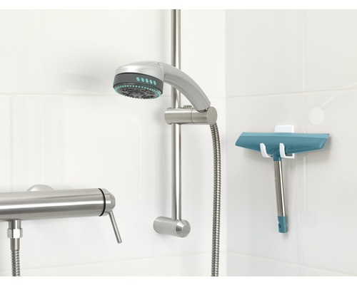 Robinet de salle de bain avec pommeau de douche et raclette de douche au mur.