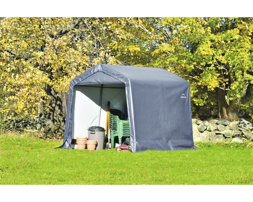 Tente de jardin avec outils et mobilier de jardin sur pelouse