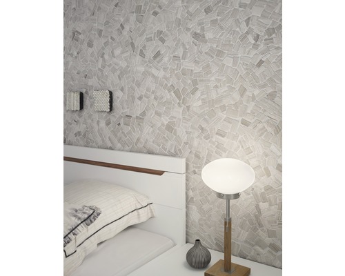 Schlafzimmer mit Mosaikwand, Nachttischlampe und weißem Bett