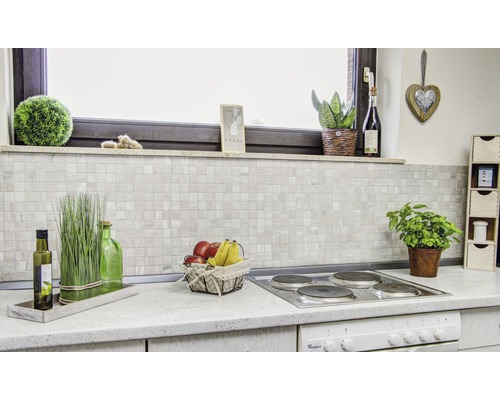 Scène de cuisine avec crédence en mosaïque et décorations sur le plan de travail.