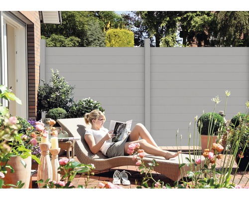 Szene im Garten mit Sichtschutzzaun und entspannender Frau