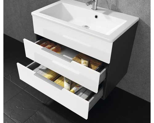 Meuble sous-lavabo avec deux tiroirs ouverts et divers articles de salle de bain