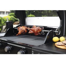 Gasgrill mit zwei Brathähnchen auf einem Drehspiess und Zitronen auf einem Holzbrett