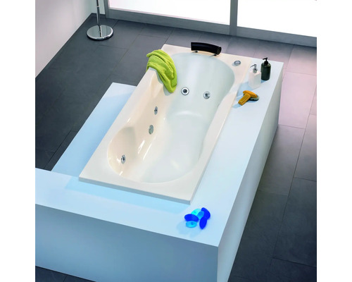 Eingebaute Badewanne mit Handtuch, Badezusätzen und Armaturen im Badezimmer