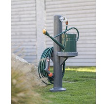 Scène de jardin avec borne fontaine, arrosoir et tuyau d''arrosage.