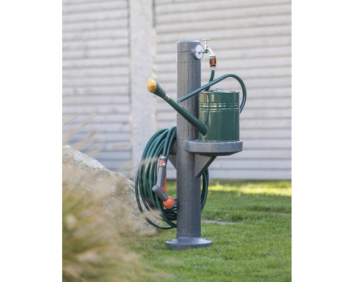 Scène de jardin avec borne fontaine, arrosoir et tuyau d''arrosage.