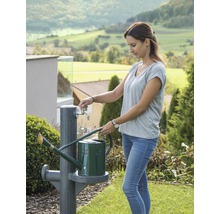 Femme remplissant un arrosoir à un robinet de jardin