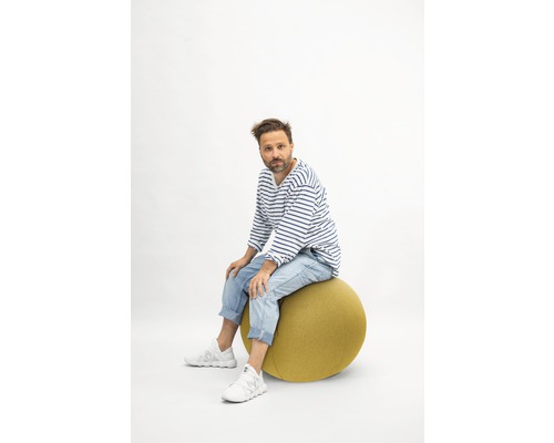 Mann sitzt auf einem Gymnastikball