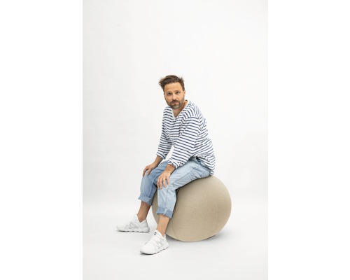 Mann sitzt auf einem Gymnastikball