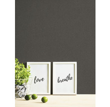 Papier peint avec plantes, cadres avec inscriptions et citrons verts sur une table
