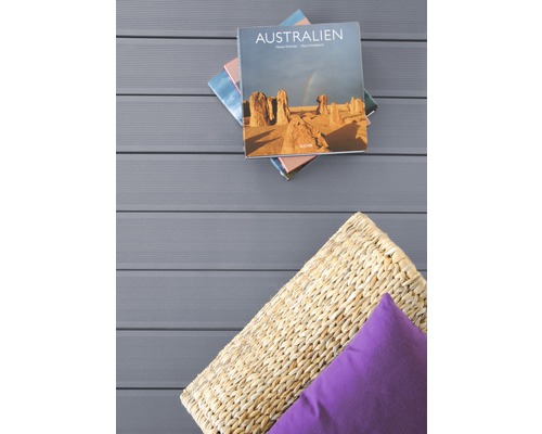 Lames de terrasse avec coussin, panier en rotin et livres empilés