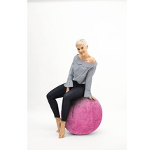 Femme assise sur un ballon de gymnastique rose