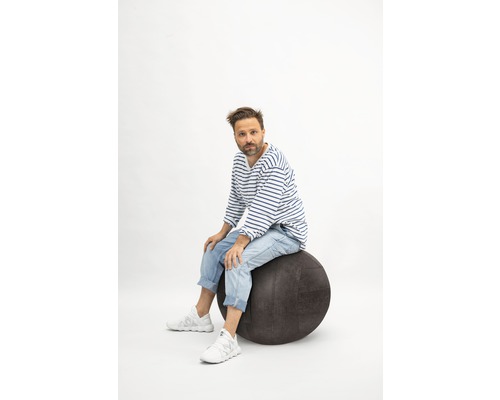 Homme assis sur un ballon de gymnastique.