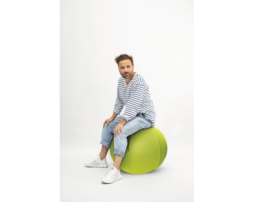 Mann sitzt auf einem Gymnastikball